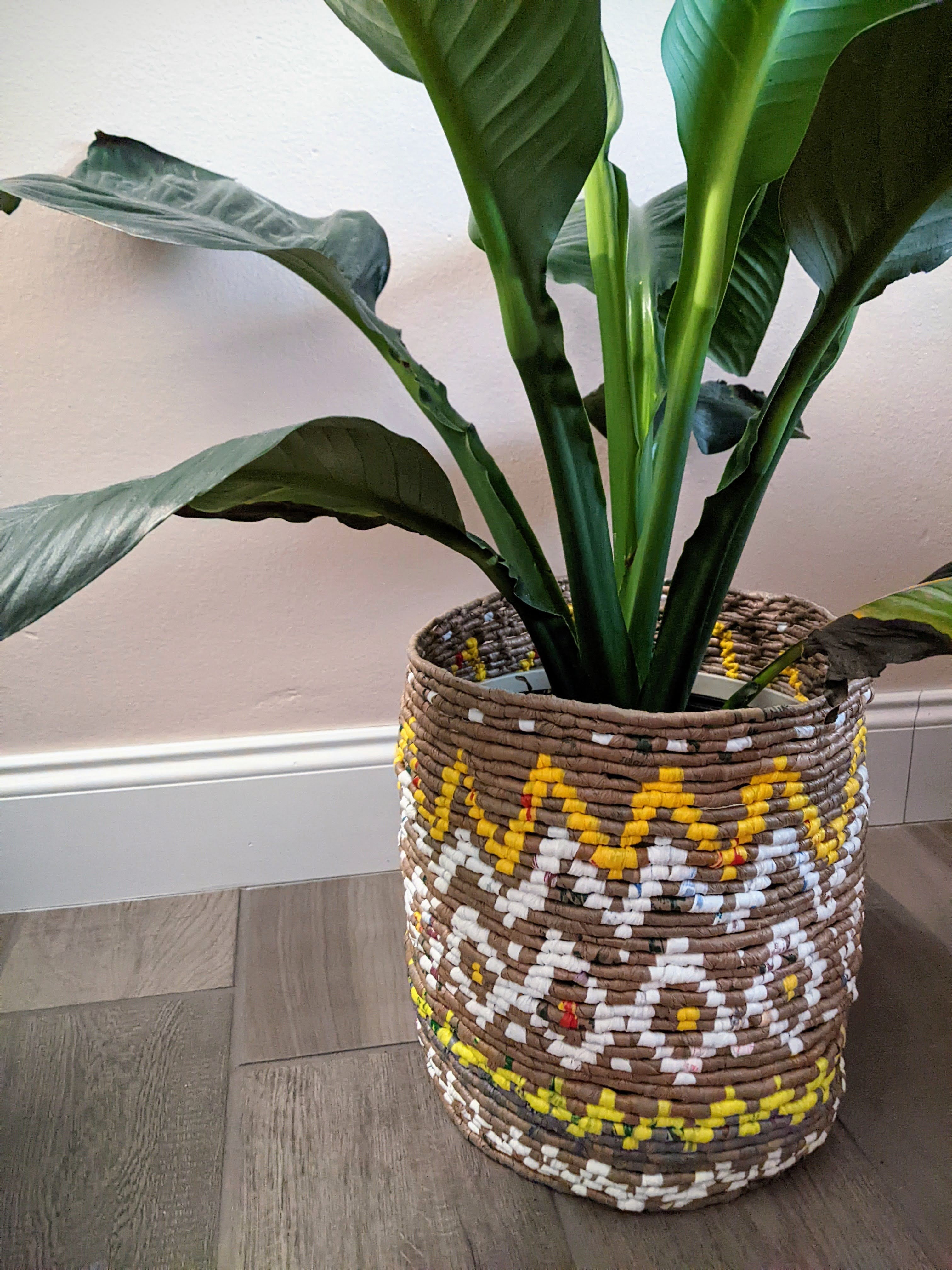 A multi-color plant cozy I wove to upcycle disposable plastic grocery bags